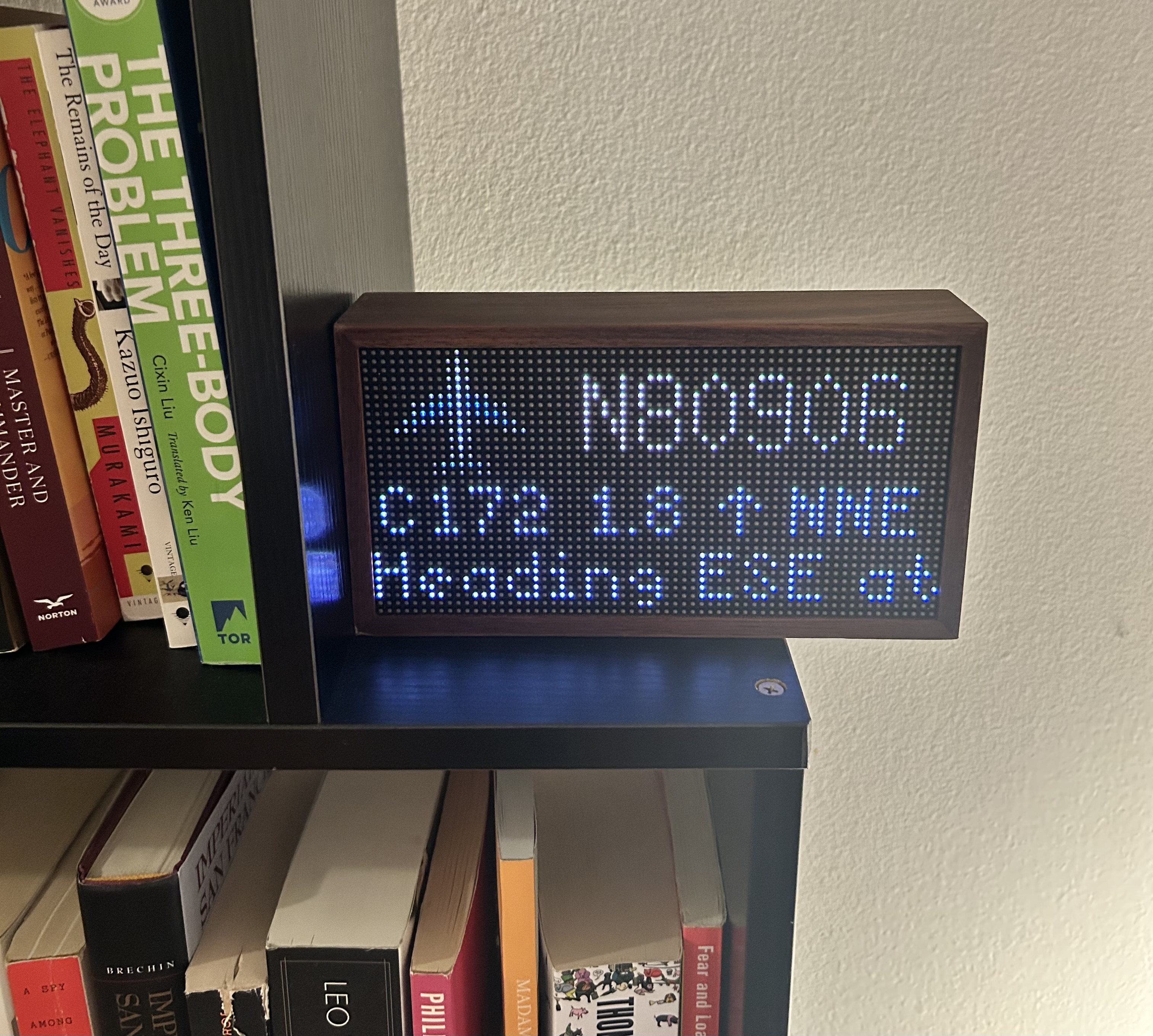 Photo of Tidbyt Planes Overhead App Running on Smart Display on Bookshelf